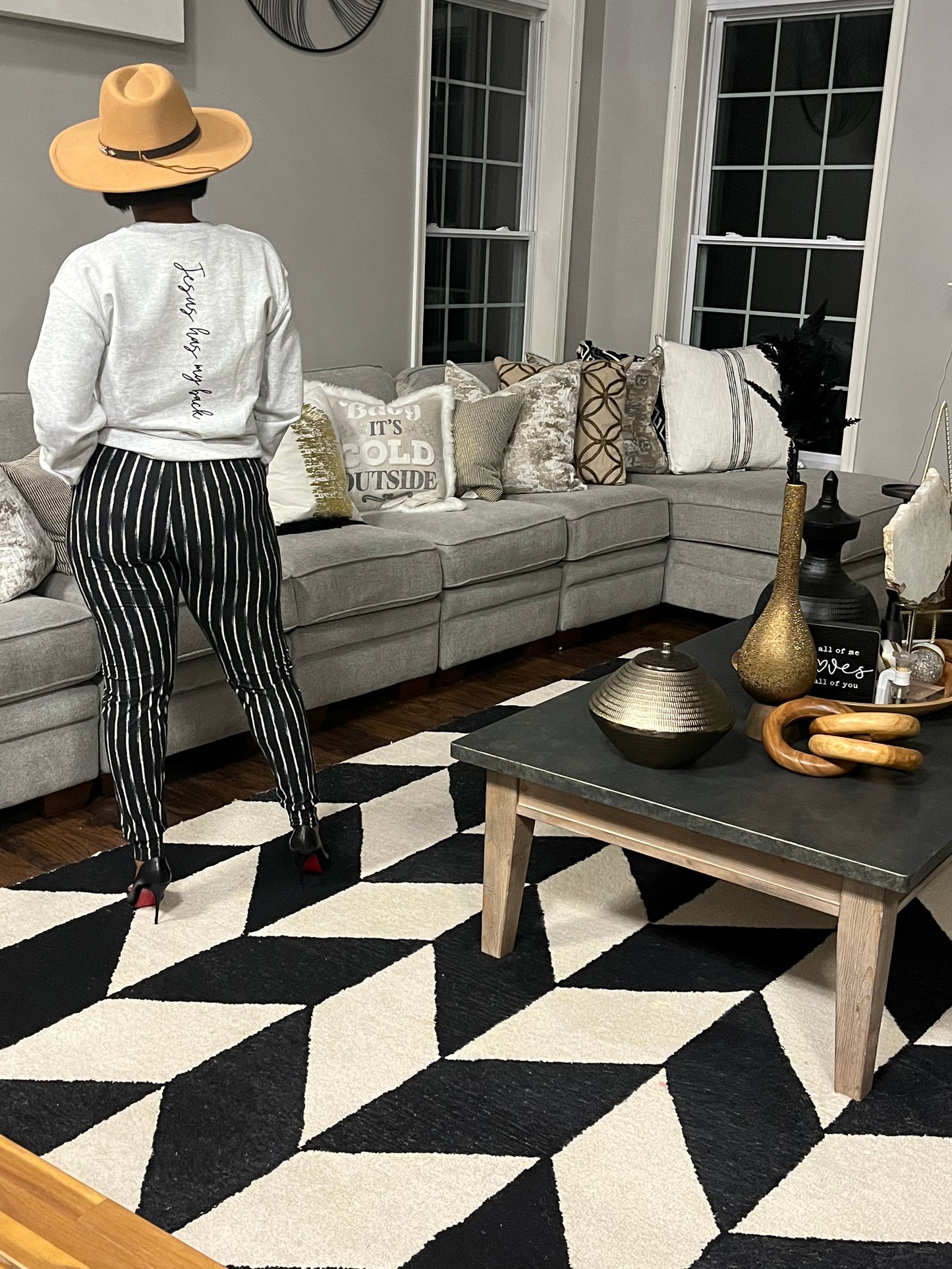 Woman wearing graphic sweatshirt and black and white striped pants